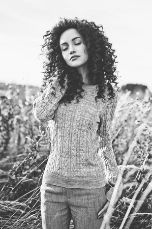 Outdoor atmospheric lifestyle photo of young beautiful lady. Brown hair and eyes. Warm fall. Autumn vibes. Softness, warmth and comfortの写真素材
