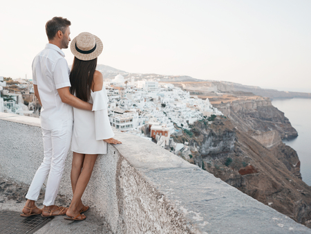 Outdoor lifestyle photo of happy young couple in white european town. Walking on Santorini islandの写真素材