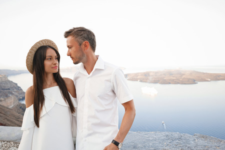 Outdoor lifestyle photo of happy young couple in white european town. Walking on Santorini islandの写真素材