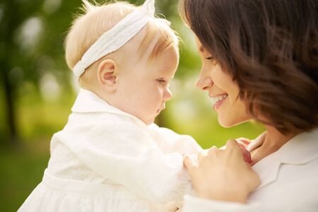Outdoor lifestyle portrait of happy young beautiful mother and little cute daughter. Family, Love and Care. Summer imageの写真素材