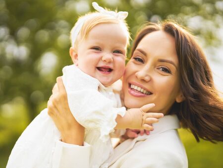 Outdoor lifestyle portrait of happy young beautiful mother and little cute daughter. Family, Love and Care. Summer imageの写真素材