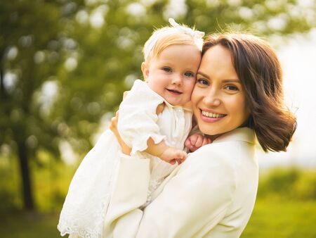 Outdoor lifestyle portrait of happy young beautiful mother and little cute daughter. Family, Love and Care. Summer imageの写真素材