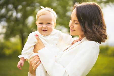 Outdoor lifestyle portrait of happy young beautiful mother and little cute daughter. Family, Love and Care. Summer imageの写真素材