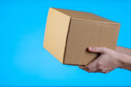 Shop assistant gives the parcel, isolated, blue backgroundの写真素材
