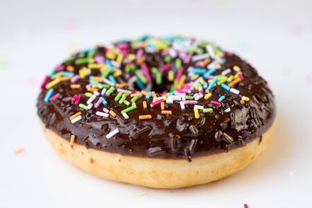 Candy chocolate on frosted doughnut.の写真素材
