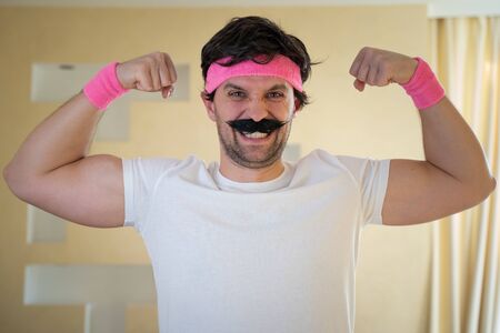 Funny retro sportsman shows biceps and looking at camera.の写真素材