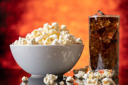 Glass bowl with fresh popcorn and colaの写真素材