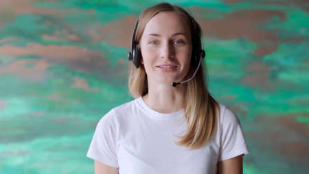 Business woman wears headset talks to web camera making distance online video conference call....