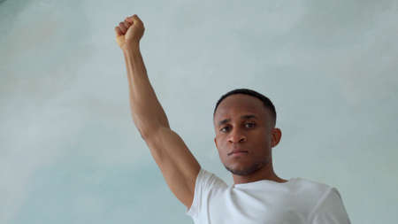 Close portrait of a black man with his fist raised up. Black lives matterの写真素材
