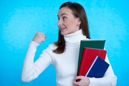 Woman raising his hand with fist having good mood celebrating victory, passes exams, completed work,...
