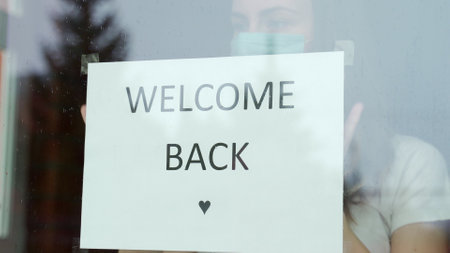 Woman stickers Welcome back re-opens after the end of the virus quarantine in the cafe the coffee shop is ready for serviceの写真素材
