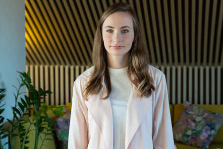 Smiling woman looking at camera posing alone at home, happy woman looks at the camera