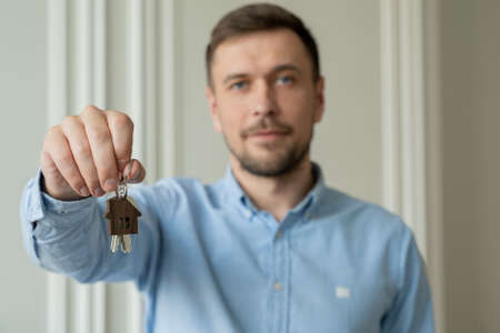 Man shows the keys to his new apartment in the living room.の写真素材