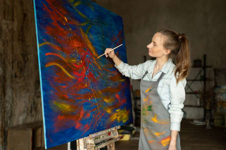 Young woman artist painting creative painting back view.の写真素材