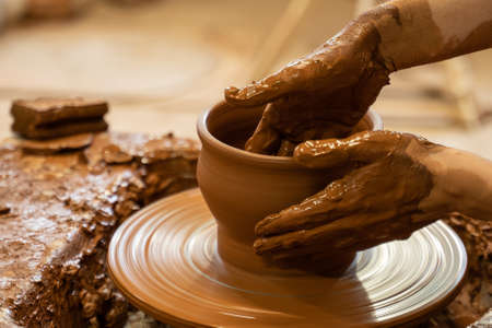 Hands of a potter, creating an earthen jar on the circle. Woman makes hand made ceramics from clayの写真素材