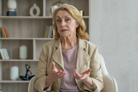 Senior mature older woman online teacher talking to webcam, virtual consultation conferenceの写真素材