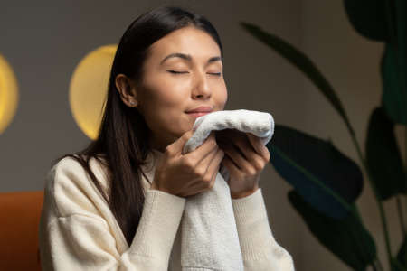 Asian woman enjoys a clean and smelling towel after washing with a new washing gelの写真素材
