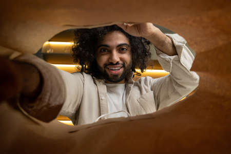 Muslim man opens paper bag to take out products from storeの写真素材