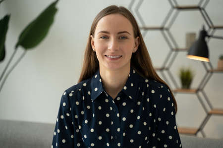 Portrait of a beautiful young brunette smiling cheerfully, showing her white teeth to the camera.の写真素材