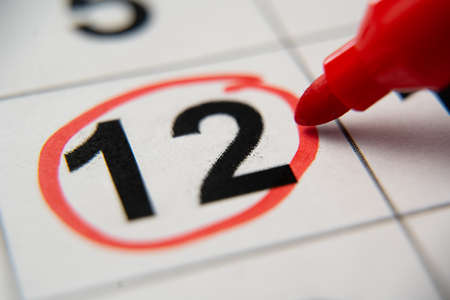 The calendar 12th day of the month is circled. A red marker circles the twelfth day of the month from the paper calendar. A very important date in the calendarの写真素材