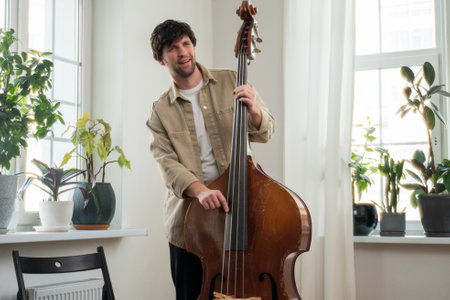 View of a musician playing the double bass in the living room. Musical instrument.の写真素材