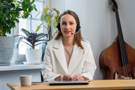 A woman, a call center and a laptop. Portrait of a happy consultant employee communicating with clients with a smile.の写真素材