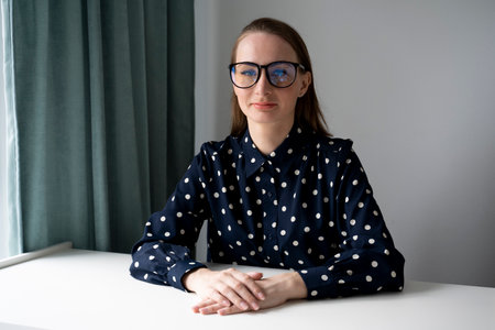 Portrait of a young businesswoman-boss, female employees seriously looking at the camera, a woman with glasses at a desk inside the office.の写真素材