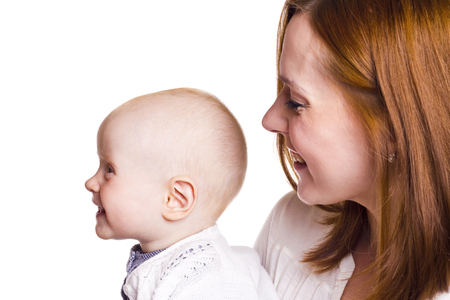 happy young mother looks at her baby girl. profile. white background.の写真素材