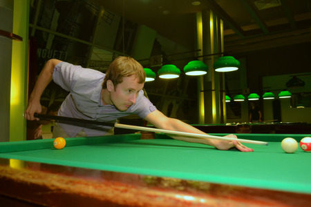 man is playing billiard in the barの写真素材