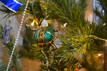 figurine of jester on the christmas tree amongst lights and garlandの写真素材