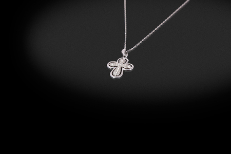 Precious silver chain with cross diamonds on a black background. Good material for design jewelery.の写真素材