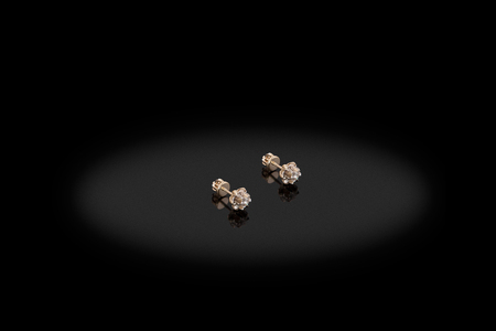 Yellow gold precious earrings with big diamonds on black background. Good material for design jewelery.の写真素材