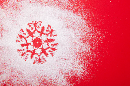 White, snow, stencil snowflake, sweet icing sugar on a red background, congratulations on Christmas...