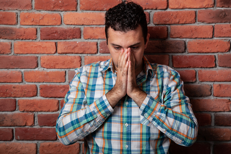 Male portrait Italian, good positive emotions against the background  fire wall in style loft. In klechatoy shirt, jeans and sneakers, urban clothing.の写真素材
