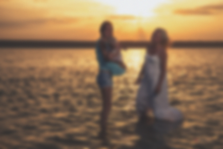 Blurred - young  family at sunset on the lake. Very emotional moment.の写真素材