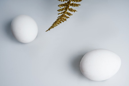 Natural chicken eggs is a symbol of Easter. Golden palm leaves.