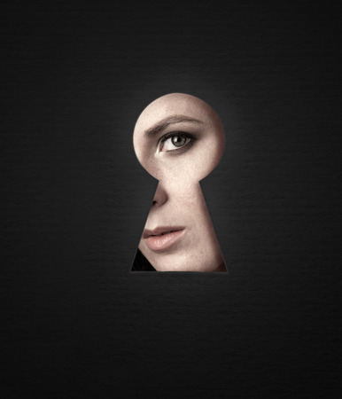 The girl is curious, emotionally peeping into the keyhole. Good idea to post.の写真素材