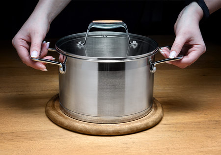 Metal saucepans in the kitchen with natural ingredients for making vegetarian soup.