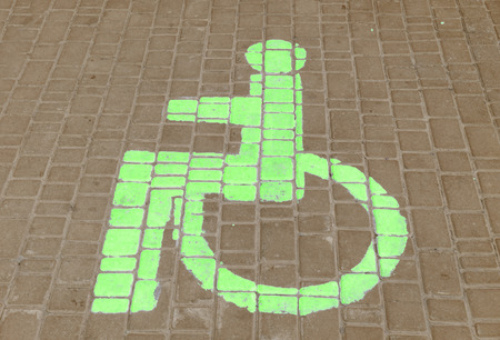 The parking space of cars for disabled people the drawn sign on road tile.の写真素材
