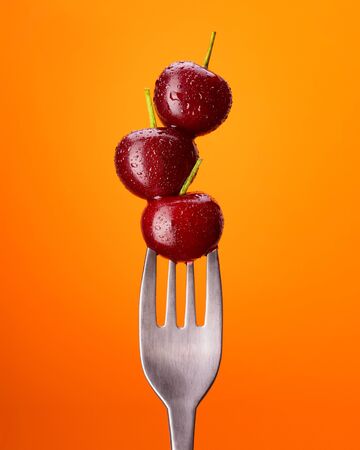 Natural cherry on a fork with water drops. Oreginal concept. Front view.の写真素材