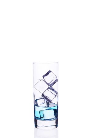 Glass beaker is filled with a blue cocktail ice cubes on a whiteの写真素材