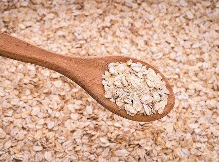 Natural oatmeal flakes, healthy food ingredients with vitamins. Background texture view from the top...
