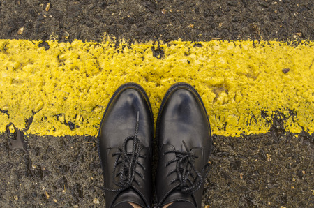 Women's black boots on the yellow border lineの写真素材