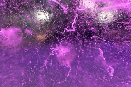 Abstract background of illuminated purple ice texture with air bubbles inside, cracks and backlightsの写真素材