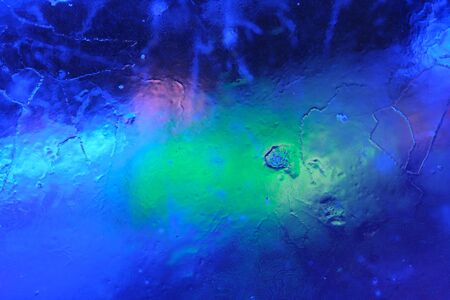 Abstract background of illuminated glossy transparent colored ice textureの写真素材