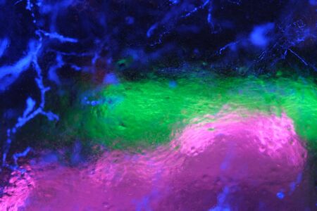 Abstract background of illuminated glossy transparent colored cracked ice textureの写真素材