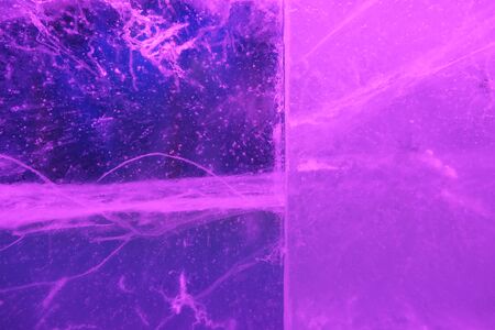 Abstract background of illuminated glossy transparent colored ice texture divided into two partsの写真素材