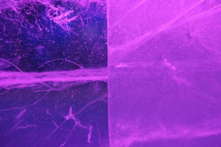 Abstract background of illuminated glossy transparent colored ice texture divided into two partsの写真素材