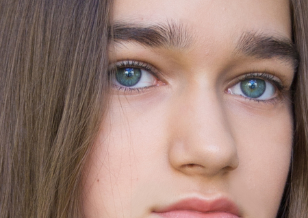 Beauty young woman teen teenage girl portrait with perfect fresh and healthy skin without make up with green eyes. Spa, youth and skin care concept. Close Up.の写真素材