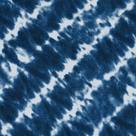Jeans fashion background. Blue color grunge seamless texture. Textile cotton textured fabric. Tie dye elements diagonal stripes pattern on denim material.の写真素材